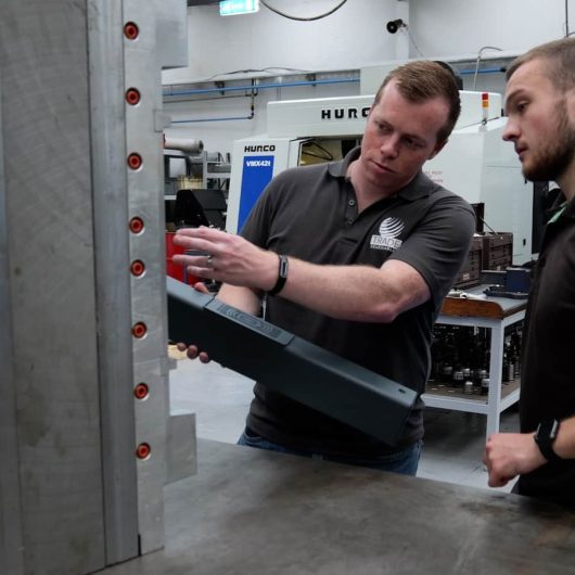 Engineers inspecting large mould tool component at Crossen Engineering.